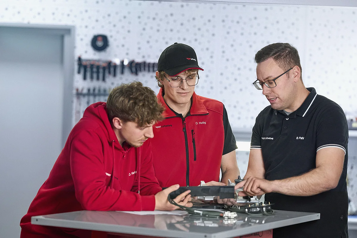 Three employees of the Part-21 design organisation are talking.