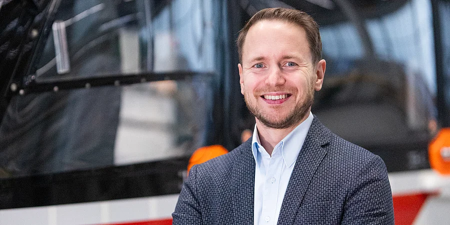 Portraitaufnahme von Michael Jag vor einem Hubschrauber im Hangar der DRF Aviation Services.